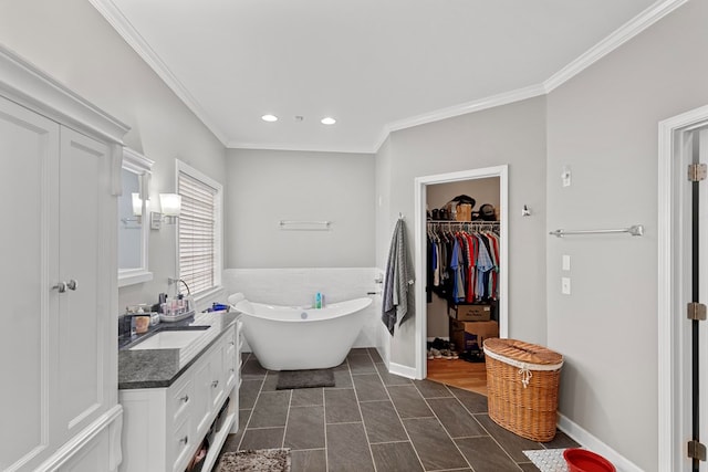 bathroom featuring ornamental molding, vanity, and a tub