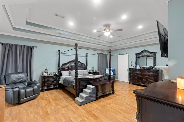 bedroom featuring ceiling fan, a raised ceiling, crown molding, and light hardwood / wood-style flooring