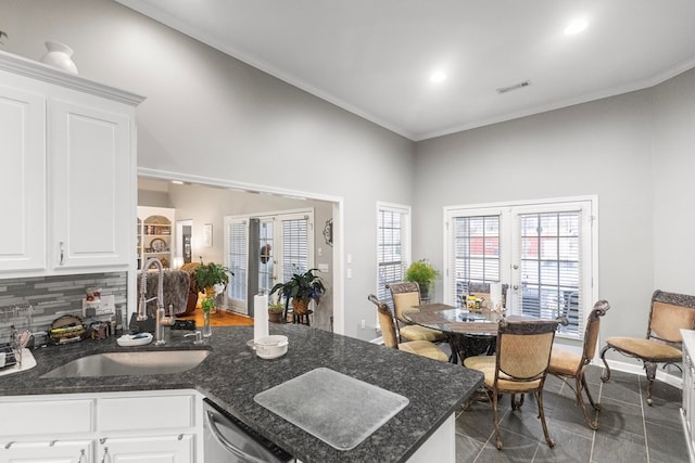 kitchen with dishwasher, tasteful backsplash, white cabinetry, and french doors