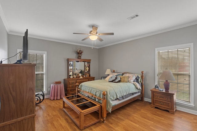 bedroom featuring ceiling fan, crown molding, and light hardwood / wood-style flooring