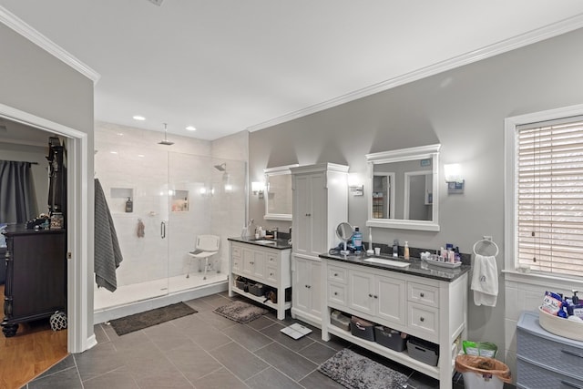 bathroom with tile patterned flooring, vanity, a shower with door, and ornamental molding