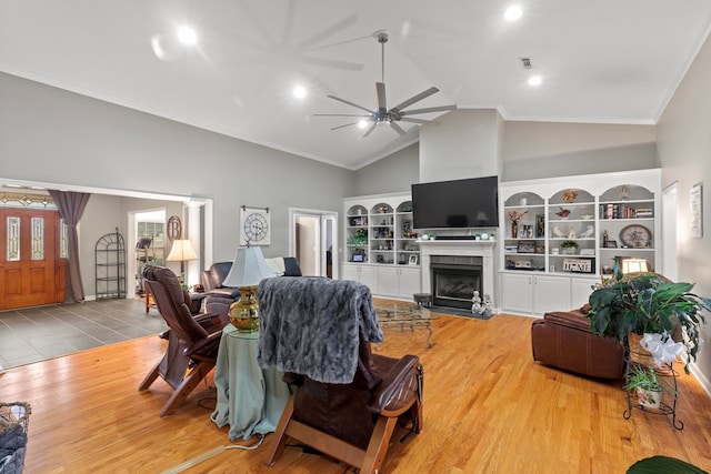 living room with a fireplace, hardwood / wood-style floors, high vaulted ceiling, and ceiling fan