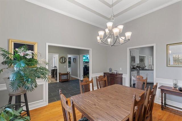 dining area featuring a chandelier, wood-type flooring, and ornamental molding