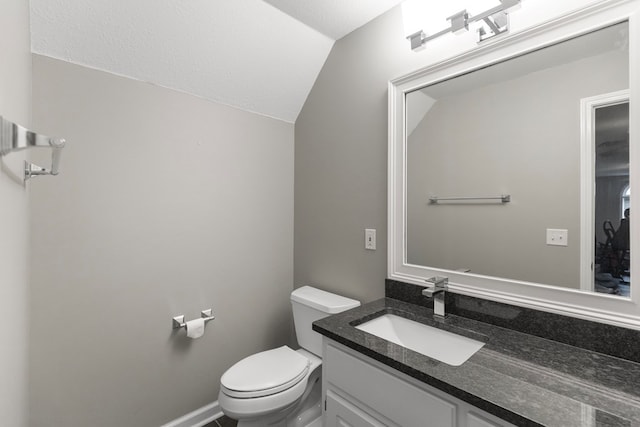 bathroom with toilet, a textured ceiling, vanity, and vaulted ceiling