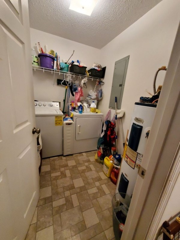 clothes washing area featuring water heater, washer and dryer, electric panel, and a textured ceiling