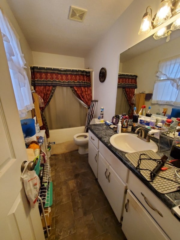 full bathroom featuring vanity, toilet, and shower / bathtub combination with curtain