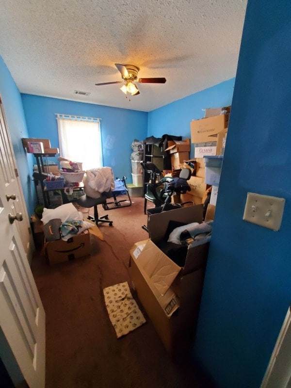 office area with ceiling fan, a textured ceiling, and carpet flooring