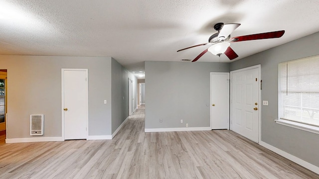 806 County Road 23, Skipperville, AL 36374 - unfurnished living room with light wood-style flooring, ceiling fan, heating unit, and a textured ceiling