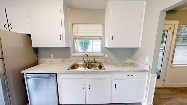 806 County Road 23, Skipperville, AL 36374 - kitchen with appliances with stainless steel finishes, white cabinets, light countertops, and wood finished floors