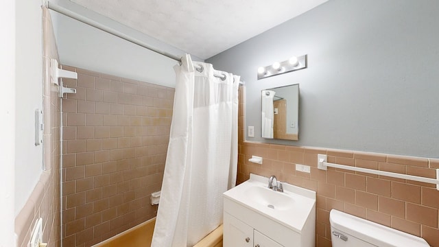 806 County Road 23, Skipperville, AL 36374 - full bathroom with vanity, tile walls, shower / bath combo with shower curtain, and a wainscoted wall