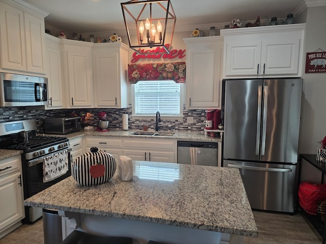 526 Ridgeland Rd, Dothan, AL 36301 - kitchen featuring stainless steel appliances, a sink, a chandelier, a kitchen bar, and white cabinets