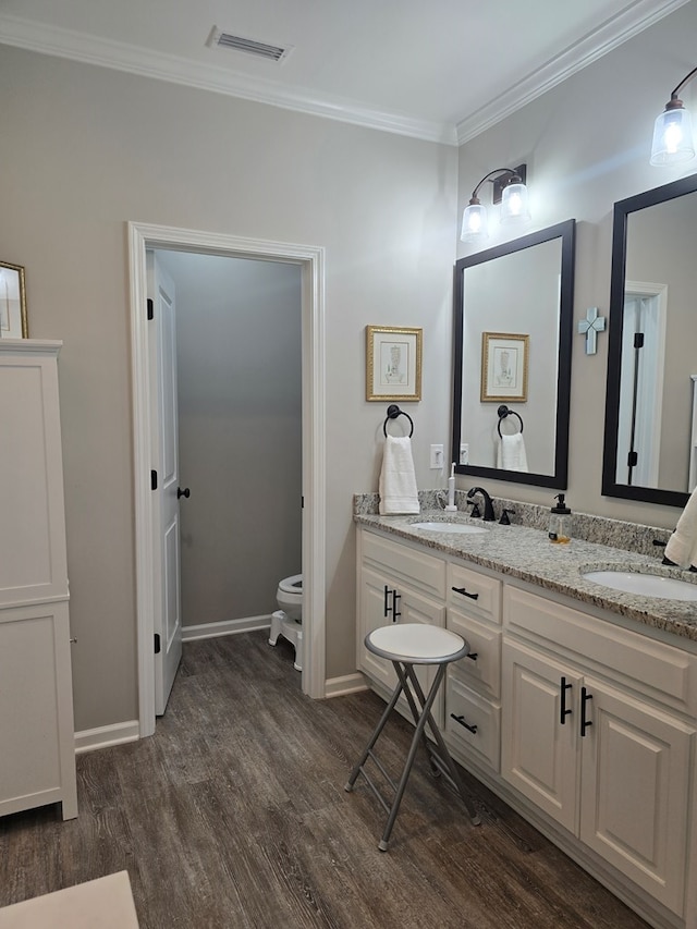 526 Ridgeland Rd, Dothan, AL 36301 - full bathroom featuring wood finished floors, toilet, crown molding, double vanity, and baseboards