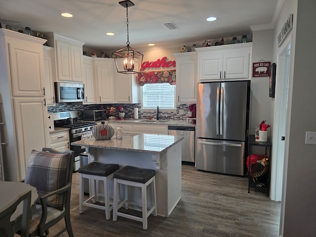 526 Ridgeland Rd, Dothan, AL 36301 - kitchen featuring appliances with stainless steel finishes, a sink, white cabinetry, decorative backsplash, and ornamental molding