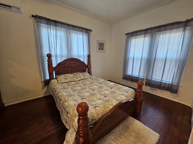 bedroom featuring wood finished floors, visible vents, and baseboards