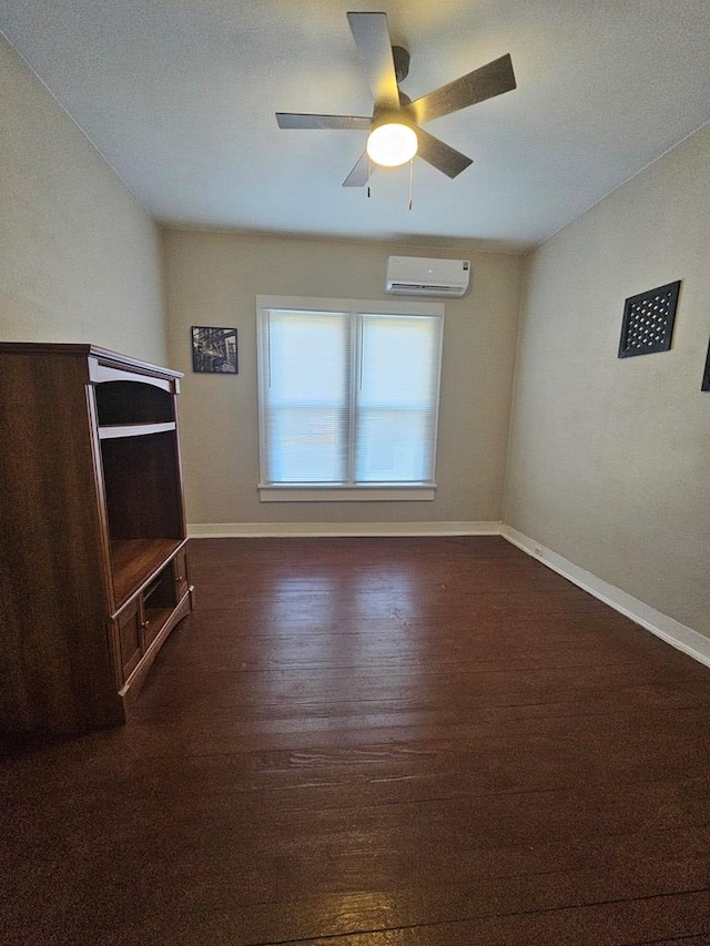 unfurnished living room featuring ceiling fan, a wall mounted AC, baseboards, and dark wood-style flooring