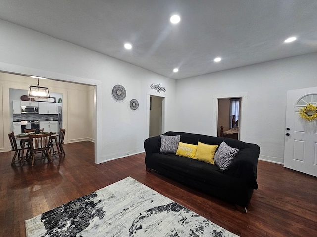 living room with dark wood-style floors, recessed lighting, and baseboards