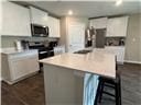 205 Mairead Dr, Dothan, AL 36301 - kitchen with stainless steel microwave, light countertops, a kitchen island, and white cabinets