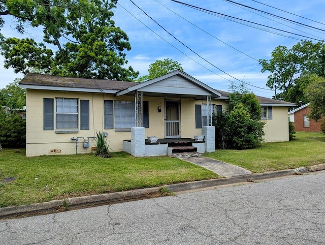 26 Martin Luther King Dr, Headland, AL 36345 - view of front facade featuring a front yard, concrete block siding, a shingled roof, and covered porch