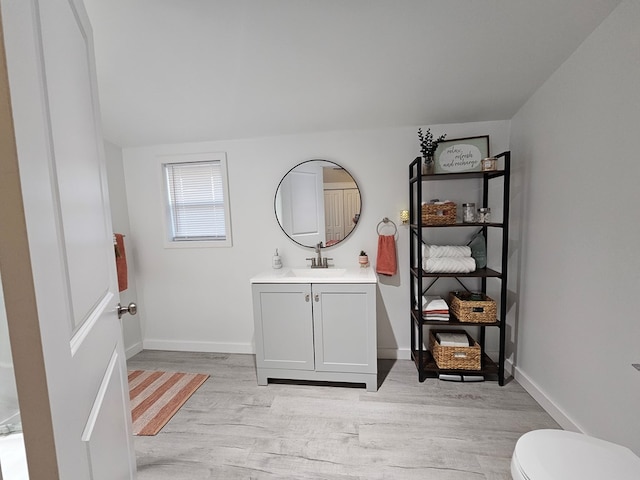 bathroom featuring toilet, hardwood / wood-style floors, and vanity