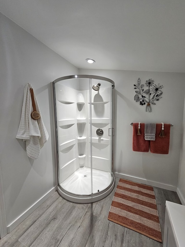 bathroom with an enclosed shower and hardwood / wood-style flooring