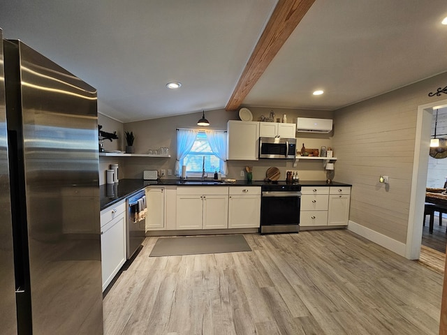 kitchen with light hardwood / wood-style flooring, an AC wall unit, stainless steel appliances, and white cabinetry