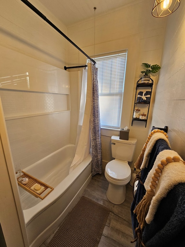 bathroom featuring hardwood / wood-style flooring, shower / bath combo with shower curtain, and toilet