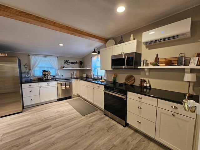 kitchen with stainless steel appliances, a wall mounted AC, and white cabinets