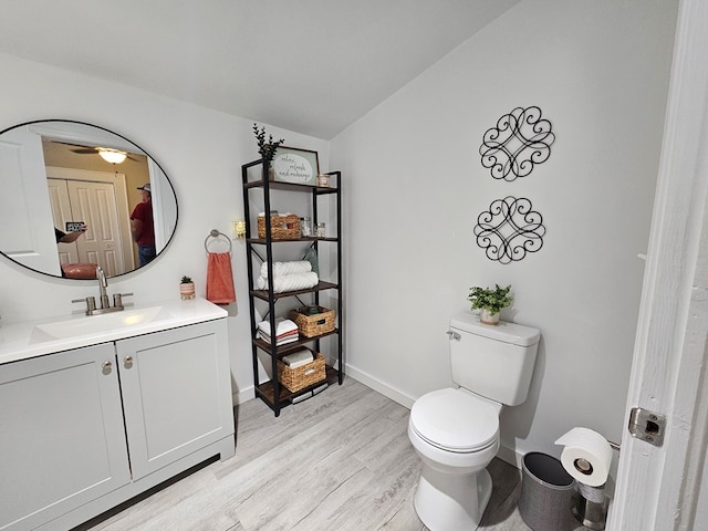 bathroom featuring lofted ceiling, vanity, toilet, ceiling fan, and wood-type flooring