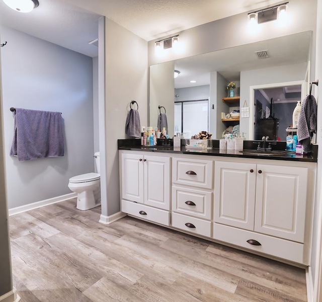 370 Airport Rd, Slocomb, AL 36375 - bathroom with double vanity, wood finished floors, toilet, and baseboards