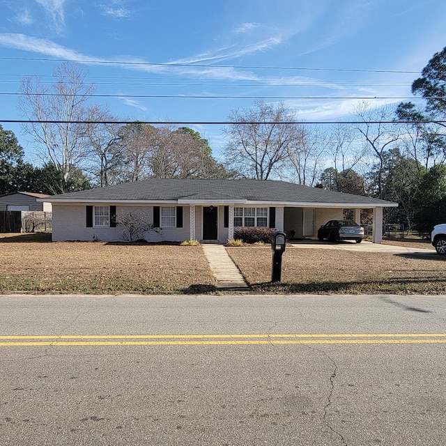 ranch-style home with a carport and a front lawn