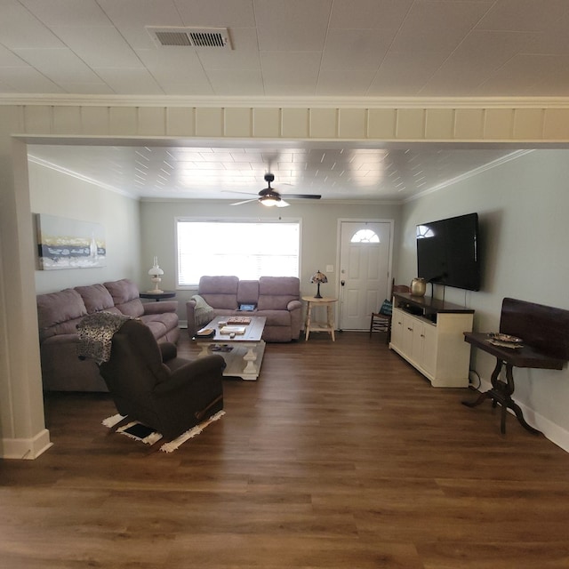 living area featuring visible vents, a ceiling fan, dark wood finished floors, crown molding, and baseboards