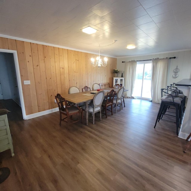 dining area featuring crown molding, a notable chandelier, wood finished floors, and baseboards