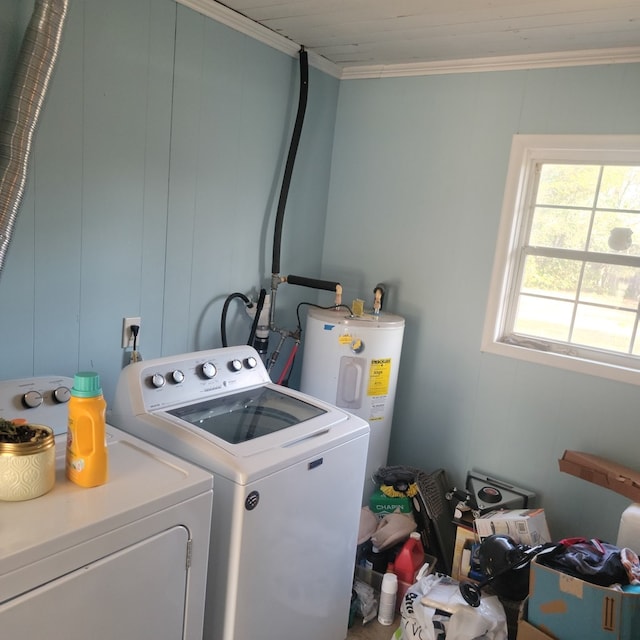 clothes washing area featuring laundry area, crown molding, electric water heater, and washing machine and clothes dryer