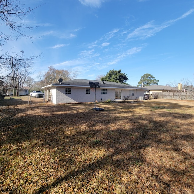 rear view of house with a yard and fence