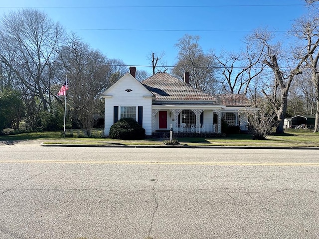 view of front of property featuring a chimney and a front lawn