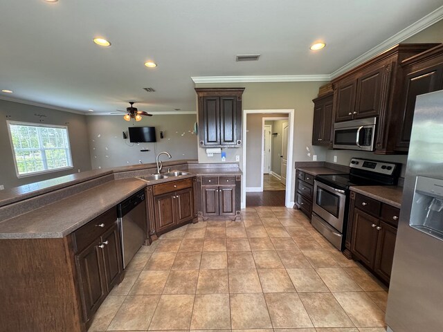 2103 Holland Rd, Newton, AL 36352 - kitchen with appliances with stainless steel finishes, a sink, ornamental molding, ceiling fan, and dark brown cabinets