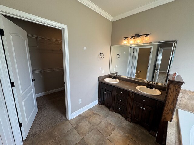 2103 Holland Rd, Newton, AL 36352 - full bath with double vanity, crown molding, a spacious closet, a tub, and baseboards