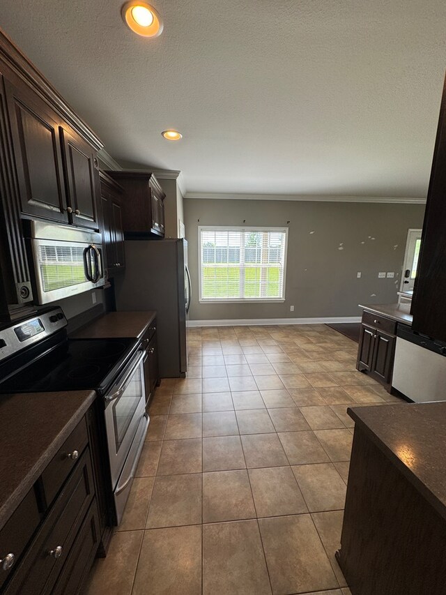 2103 Holland Rd, Newton, AL 36352 - kitchen with stainless steel appliances, ornamental molding, dark countertops, baseboards, and tile patterned flooring
