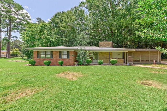 single story home featuring a sunroom and a front yard