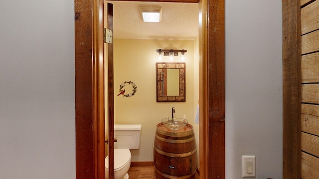 bathroom featuring a textured ceiling and toilet