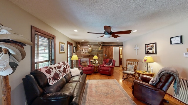 living area featuring a ceiling fan, light wood-style flooring, recessed lighting, and a textured ceiling