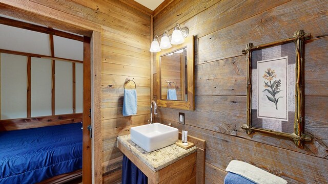 bathroom with sink and wooden walls