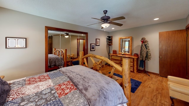 bedroom featuring light wood-type flooring, ceiling fan, a textured ceiling, and a closet