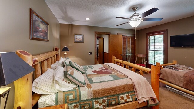 carpeted bedroom with a closet, a textured ceiling, and ceiling fan