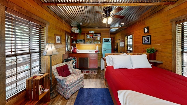 bedroom with dark hardwood / wood-style floors, wooden walls, beamed ceiling, wooden ceiling, and sink