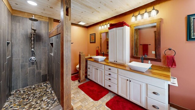 bathroom with toilet, tiled shower, ornamental molding, wooden ceiling, and vanity