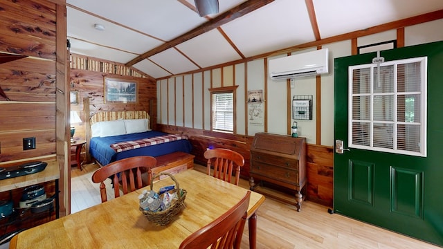 bedroom with wooden walls, an AC wall unit, light wood-type flooring, and vaulted ceiling