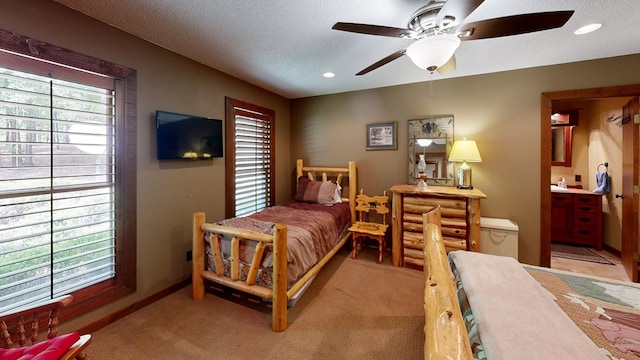 bedroom with multiple windows, light colored carpet, and a textured ceiling