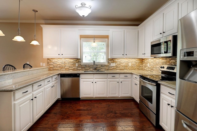 223 Veritas Dr, Dothan, AL 36303 - kitchen with appliances with stainless steel finishes, a peninsula, tasteful backsplash, white cabinetry, and crown molding