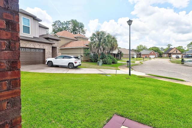 223 Veritas Dr, Dothan, AL 36303 - view of green lawn featuring driveway, a residential view, and an attached garage